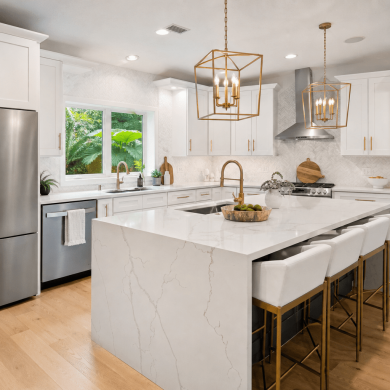 Modern kitchen remodel in Winter Park FL with white shaker cabinets, quartz waterfall island, gold fixtures and pendant lighting